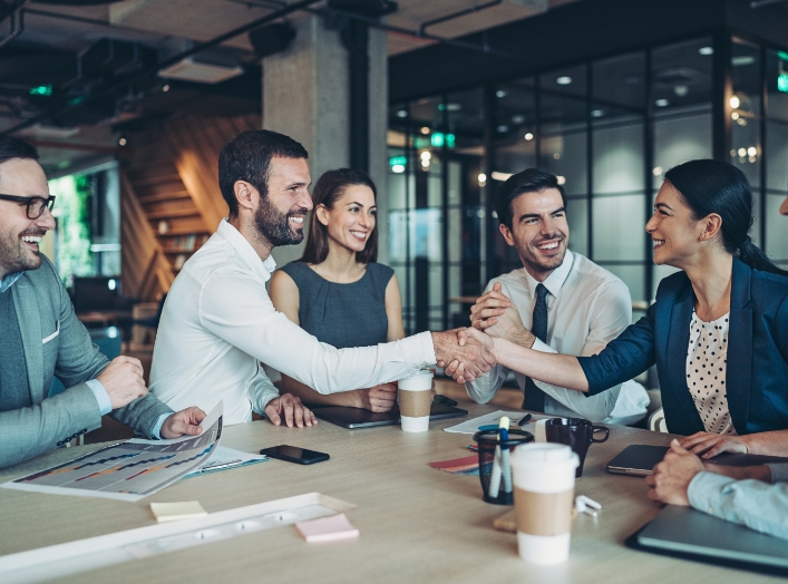 coworkers shaking hands at conference table